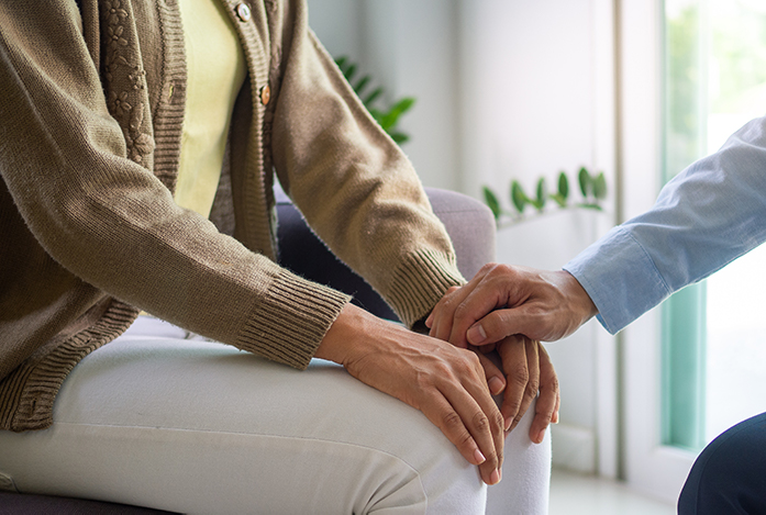 Elder woman being comforted by therapist