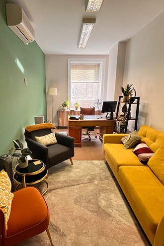 Comfortable therapy room with yellow sofa and armchairs