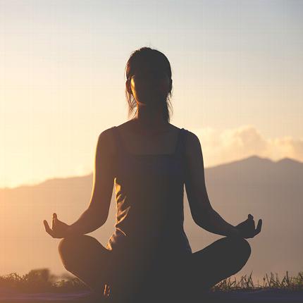 Woman meditating to manage her stress levels