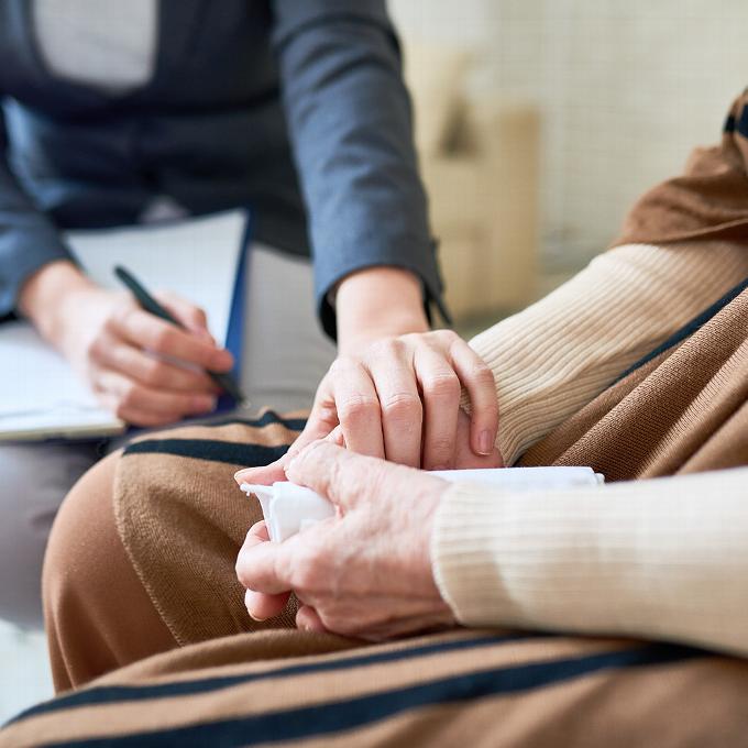 Close up of therapist consoling elderly woman during appointment